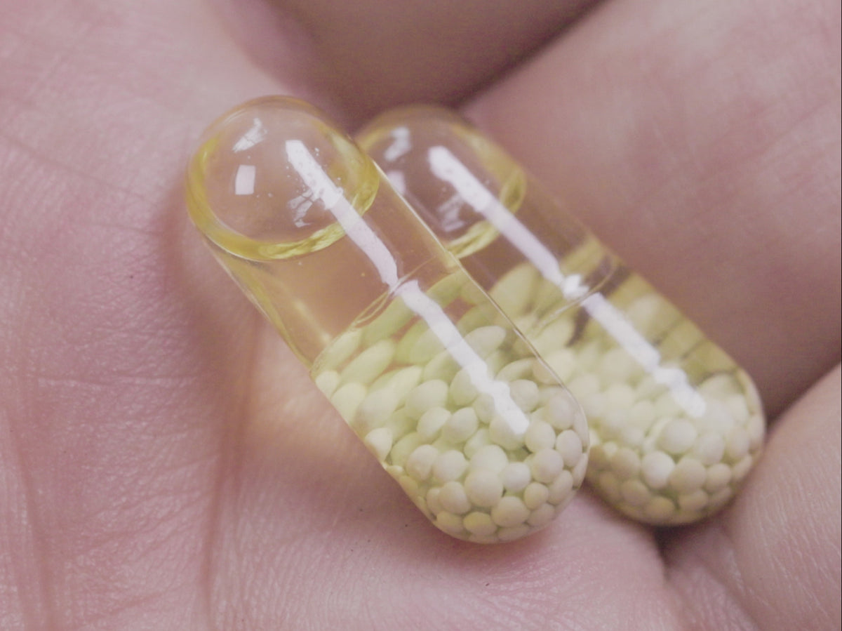 Load video: A hand holding several Ritual capsules of different formats.